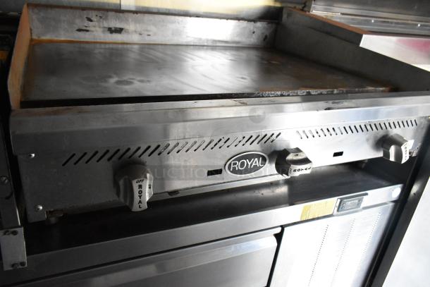 Mobile kitchen food trailer griddle, Royal brand, stainless steel, featuring control knobs. Ideal for a fully outfitted kitchen setup.