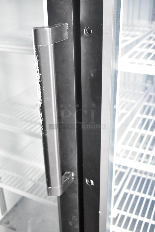Close-up of a food trailer's two-door cooler or freezer merchandiser handle, showing shelving inside.