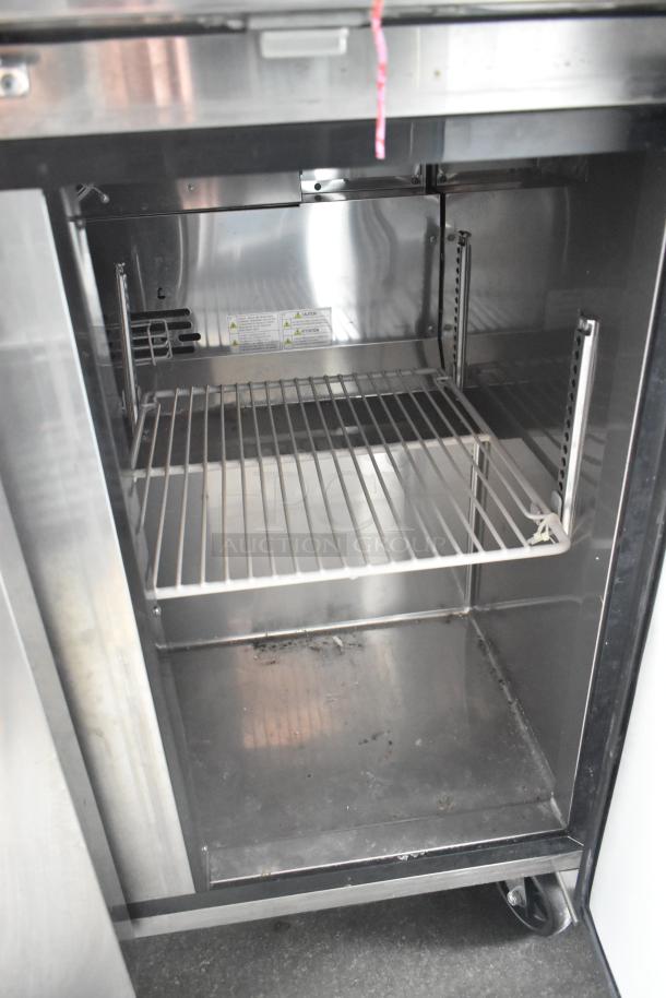 Interior of stainless steel cooler in 2020 Goodees food trailer. Features adjustable shelves and sturdy metal construction.