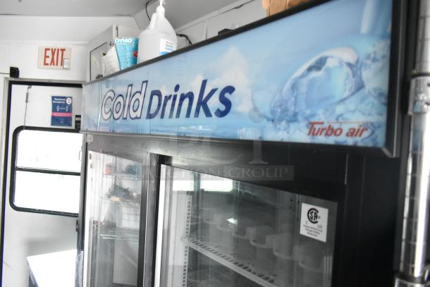 Mobile kitchen interior showing Turbo Air cooler with "Cold Drinks" signage, shelving, and various supplies.