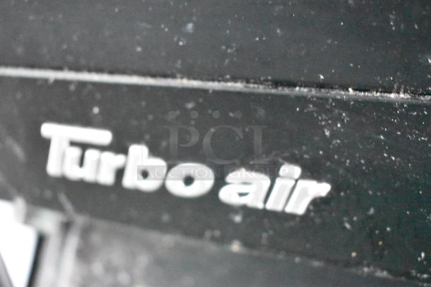 Close-up of "Turbo Air" logo on a black surface, likely a component of the 2020 Goodees food trailer's cooler or freezer.