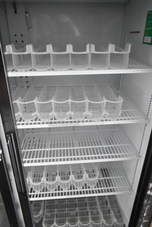 Inside view of a two-door cooler with white wire shelves and bottle holders, part of the 2020 Goodees food trailer.