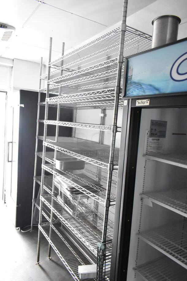 2020 Goodees food trailer interior with shelving units, cooler, and freezer merchandisers. Equipped for mobile kitchen use.