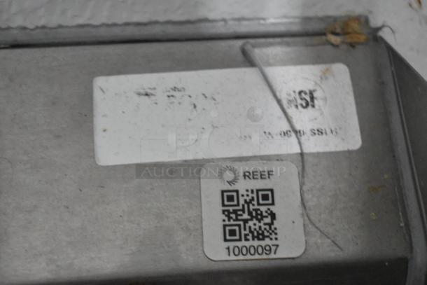 QR code labeled "REEF" with identification number 1000097 on a metal surface.