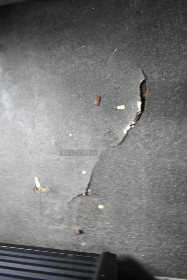 Cracked flooring inside 2020 Goodees food trailer, highlighting wear. Visible damaged section next to a rubber mat edge.