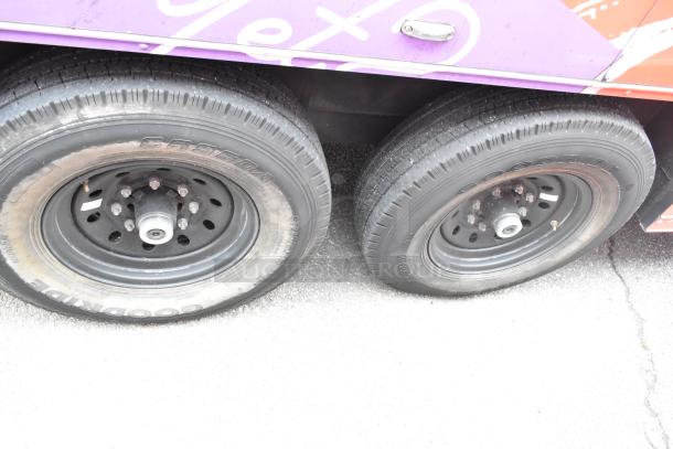 Close-up of the wheels on a 2020 Goodees Food Trailer. Goodride tires in good condition, visible purple and orange trailer body.