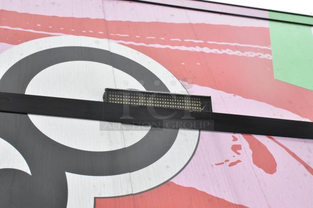 Colorful exterior of a Goodees food trailer with a graphic design detail. LED light fixture visible.