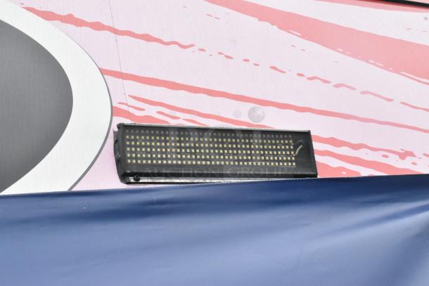 Exterior detail of 2020 Goodees food trailer, highlighting LED light fixture. Vibrant color scheme visible.