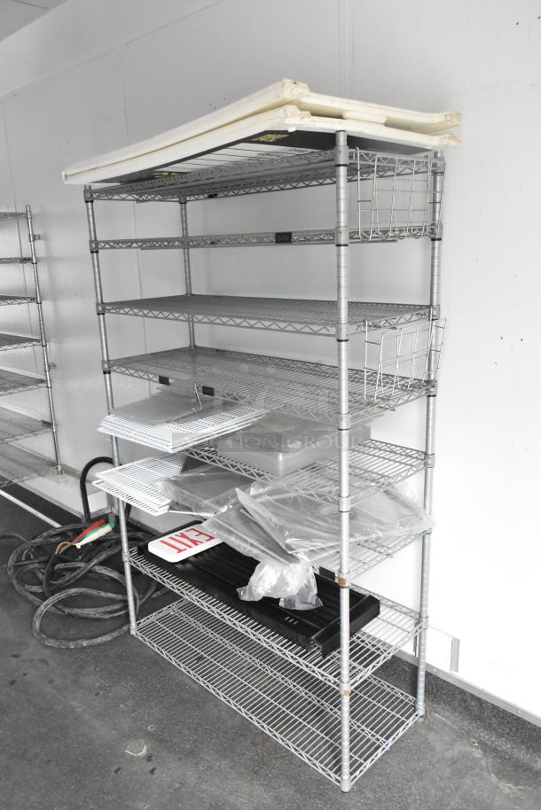 Metal shelving unit inside a 2020 Southern Dimensions Group Trailer with various components and an "EXIT" sign.