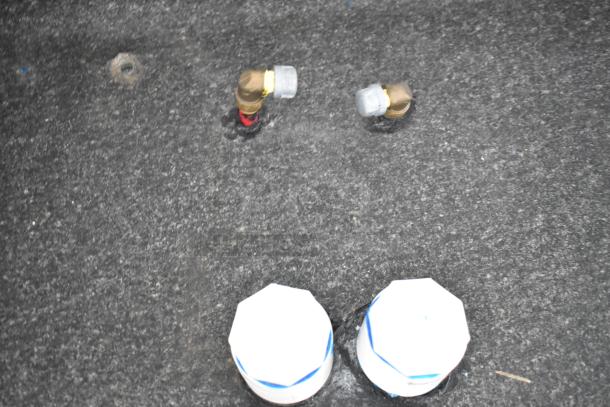 Close-up of plumbing fixtures on a 2020 Southern Dimensions Group trailer floor. Features brass fittings with protective caps. GVWR 6,350 KG.