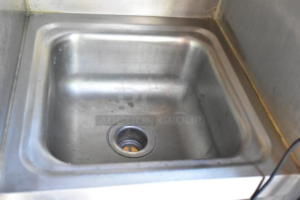 Stainless steel sink in a mobile kitchen; clean, sturdy, ideal for food prep. Part of a fully outfitted food trailer.
