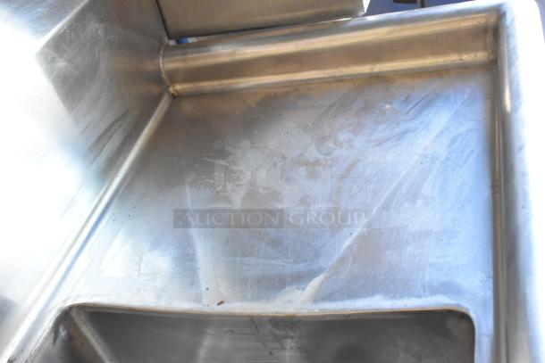 Stainless steel food prep surface inside a fully equipped mobile kitchen trailer. Clean and ready for use.