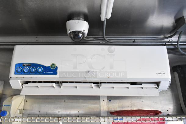 Food trailer interior with AirO-Matic inverter air conditioner. Security camera and Ecolab sanitizer dispenser visible.