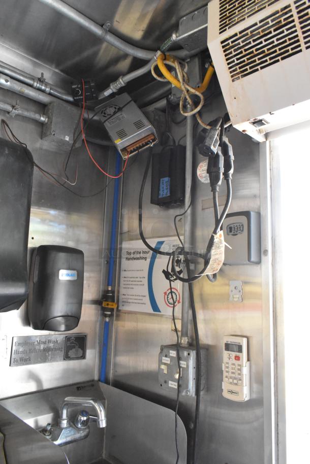 Interior of a new 2019 food trailer featuring electrical wiring, Ecolab soap dispenser, handwashing sign, and power outlets.