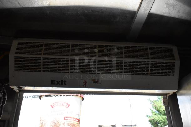 Commercial food trailer with exit sign and ventilation above door. Features equipment for mobile kitchen use.