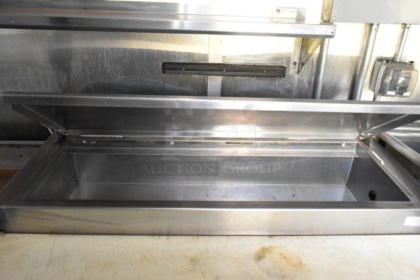 Alt text: Stainless steel food prep table with open lid inside a 2019 outfitted food trailer kitchen.