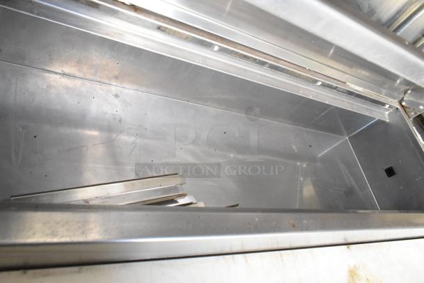 Interior view of a clean stainless steel food trailer compartment. Suitable for mobile kitchen use.