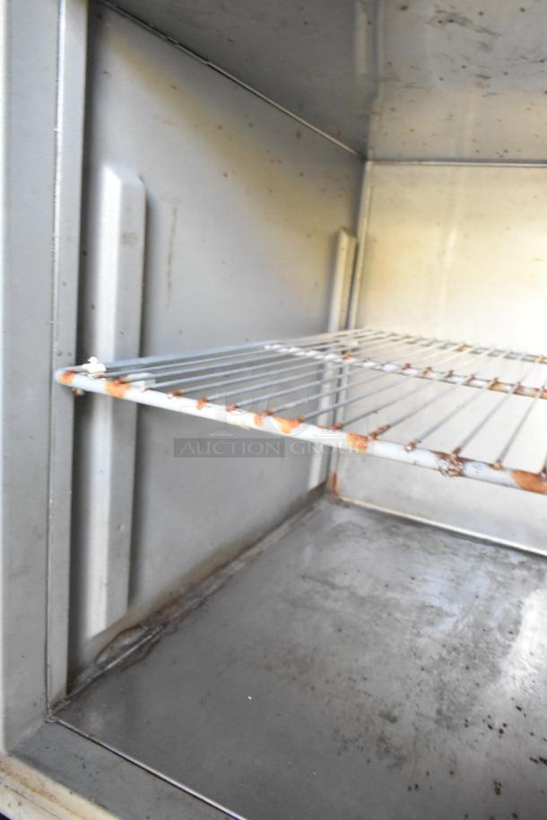 Interior of a food trailer showing a metal shelf with some rust, part of a fully outfitted mobile kitchen from 2019.