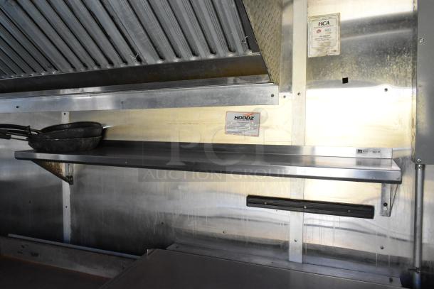 Brand new 2019 food trailer kitchen setup with grease hood, Henny Penny fryer, shelving, and safety inspection labels.