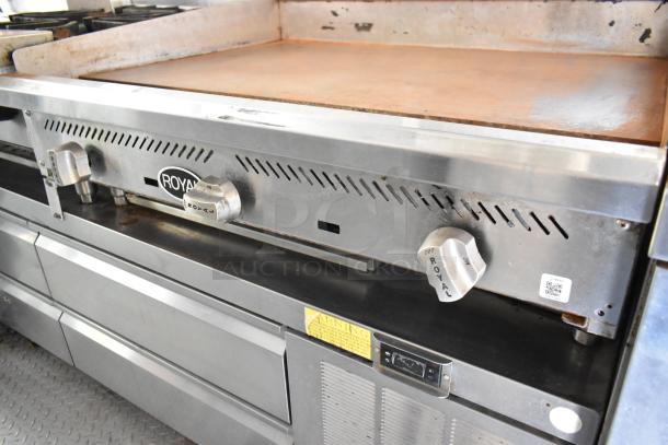 Stainless steel flat top grill in excellent condition, featuring Royal brand knobs and a sturdy base. Ideal for food trailer setup.