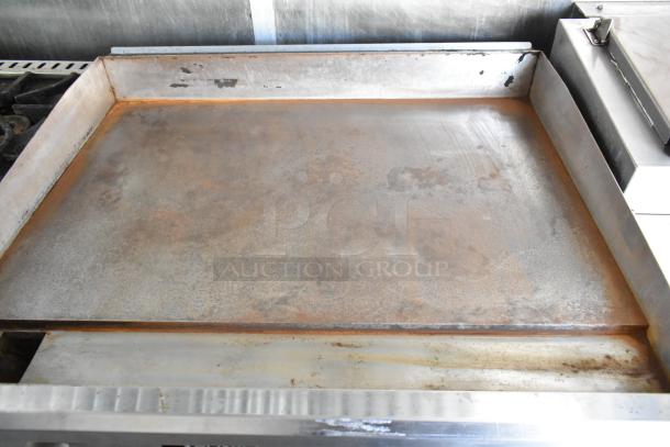 Flat top griddle on a mobile kitchen trailer, showing rust and wear, part of fully equipped 2019 food trailer setup.