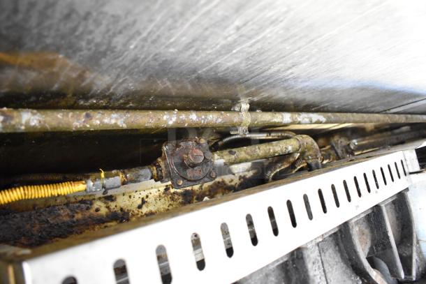 Close-up view of the undercarriage piping and wiring in a fully outfitted 2019 food trailer kitchen.