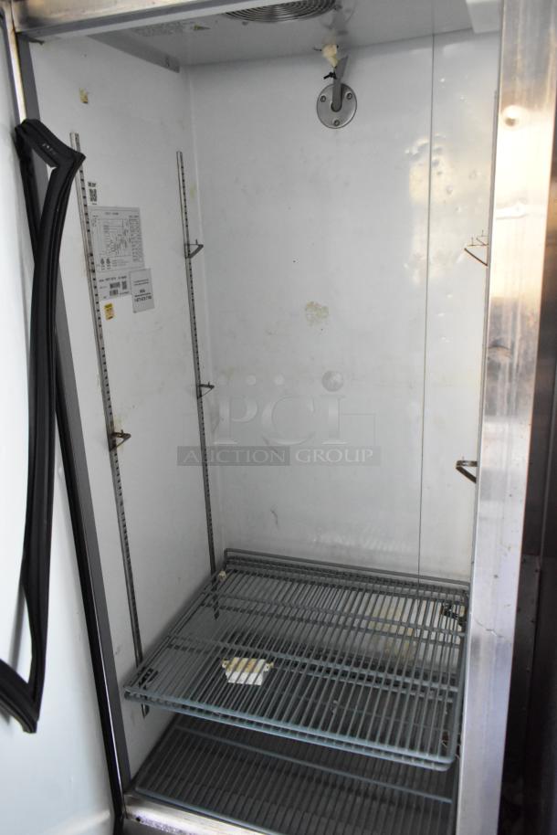 Interior of a commercial cooler or freezer in a food trailer, equipped with wire racks and visible labels, in new condition.