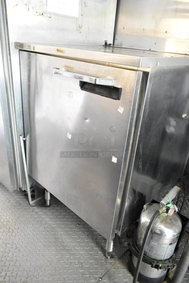 Stainless steel cooler in a food trailer, visible labels "Craftex" and "Ponzu," minor dents, connected to gas tank.