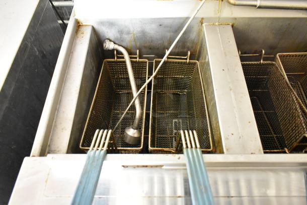 Henny Penny 2 Bay Fryer in new food trailer. Features dual baskets, stainless steel build, and integrated sprayer.