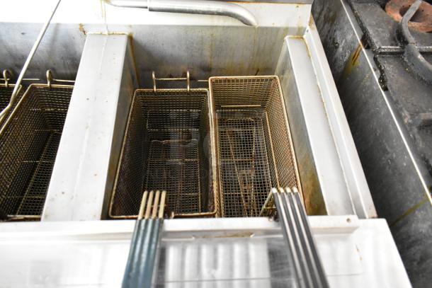 Henny Penny 2-bay fryer in mobile kitchen setup, showing dual fry baskets. Slight wear visible on stainless steel surface.