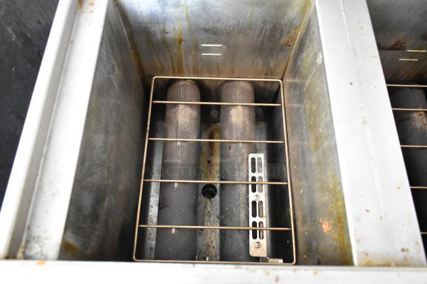 Interior view of a Henny Penny 2-bay fryer with heating elements and residue, part of a 2019 outfitted food trailer.