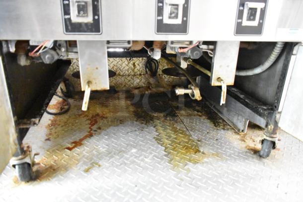 Food trailer interior showing cooking equipment including control panels and metal flooring, visibly used condition.