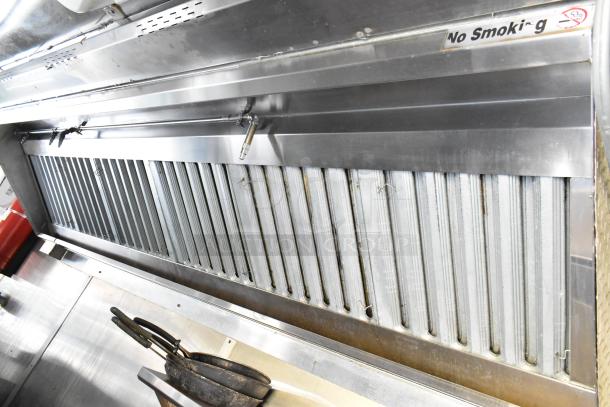 Stainless steel grease hood in a fully equipped food trailer, labeled "No Smoking," with exhaust vents.