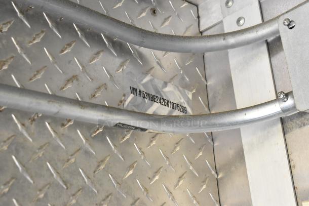 VIN tag on diamond-plate floor, showing "VIN #53NBE2426K1075269," part of the food trailer setup.