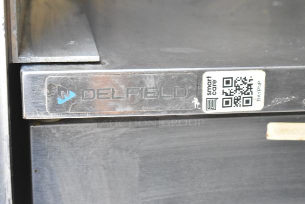 Delfield appliance label with QR code on a food trailer, indicating Smart Care service integration.
