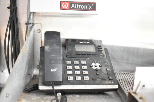 Yealink T41S IP phone with HD voice, Verizon branded, slightly dusty, set in a mobile kitchen with Altronix unit above.