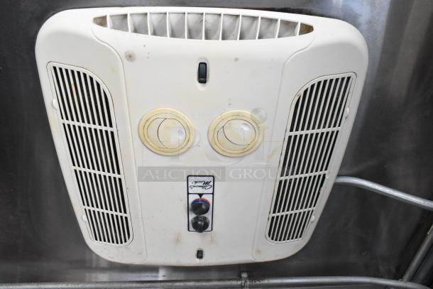 White ceiling-mounted electric vent with dual dials and central control knob, surface shows signs of use.