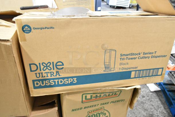 Cardboard boxes labeled "Dixie Ultra SmartStock Series-T Tri-Tower Cutlery Dispenser, Black," indicating a new unit.