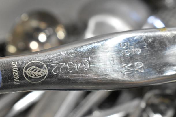 Close-up of a stainless steel kitchen utensil with markings "64322" and "59 ML". Visible leaf logo and slight surface scratches.