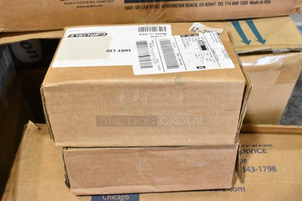 Brown cardboard boxes labeled "Carlisle" and "Cambro," containing new kitchen items like ladles, colanders, and bins.