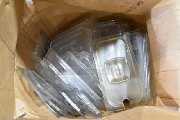 Cardboard box with assorted clear plastic Camwear bin lids, in new scratch and dent condition.