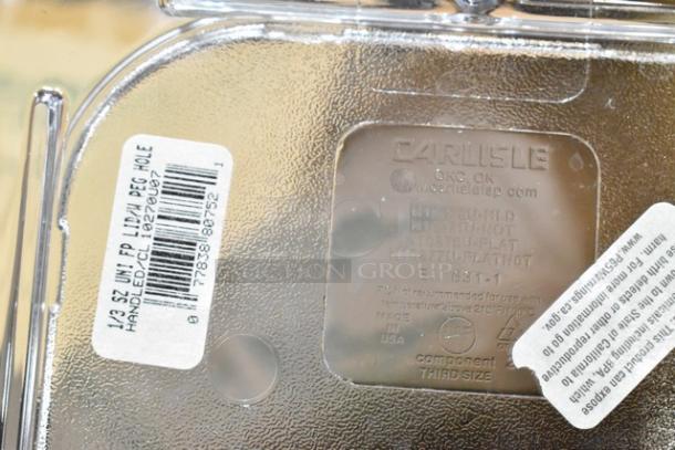 Clear plastic container lid with "Carlisle" brand label and product details. Includes barcode and handling instructions. Scratch and dent condition.