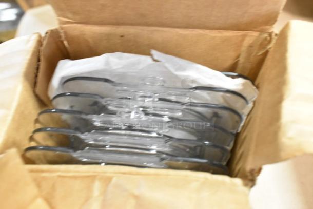 Cardboard box containing multiple Carlisle Food Pan Smart Lids, visible through open top. Lids are clear and stacked neatly.
