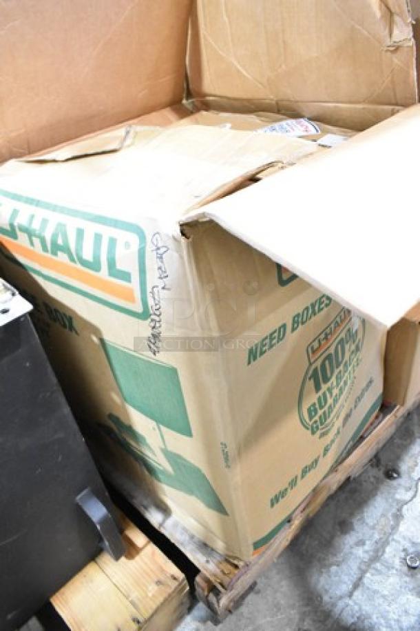 Large U-Haul box labeled "Need Boxes?" containing 25 new scratch and dent items, including Carlisle food pan lids and to-go containers.
