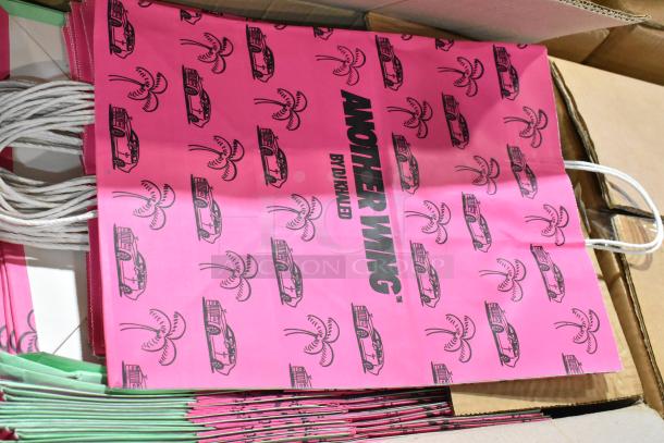 Pink paper bags with handles labeled "ANOTHER WING BY DJ KHALED," part of a 24-item scratch and dent lot.