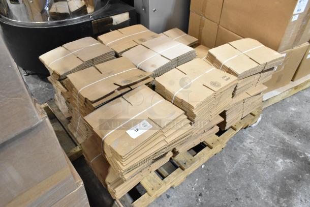 Bundles of brand new 8x6x4 cardboard boxes on a pallet, labeled with slight scratches and dents, totaling 16 sets.
