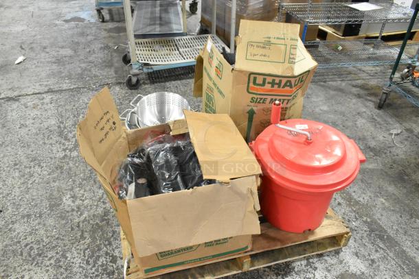 Assorted kitchen items including colanders, Winco baking pan liners, Cambro containers, and Chef Master salad spinner on a pallet.