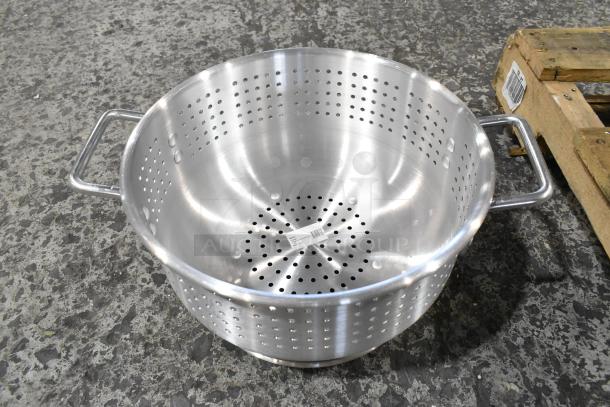 Stainless steel colander with dual handles, perforated design, and a barcode sticker on the bottom. Part of a 22-item lot.