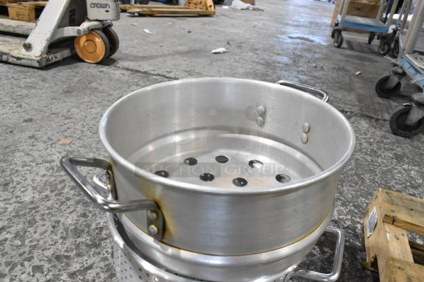 Aluminum colander with handles, stacked on another, showing signs of use. Part of a 22-item auction lot.