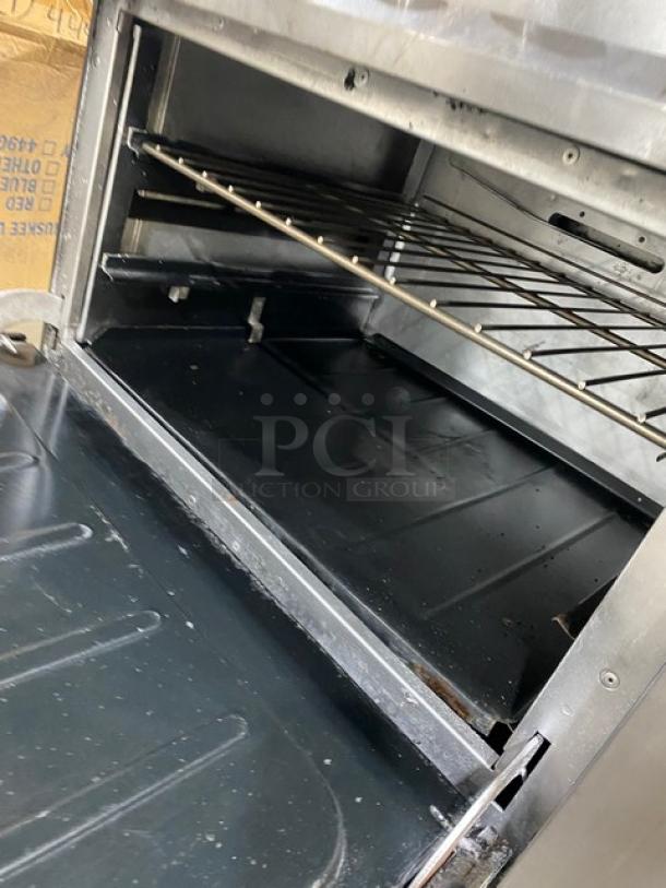 Vulcan commercial stainless steel oven interior with wired rack, shown open, featuring sturdy metal construction.